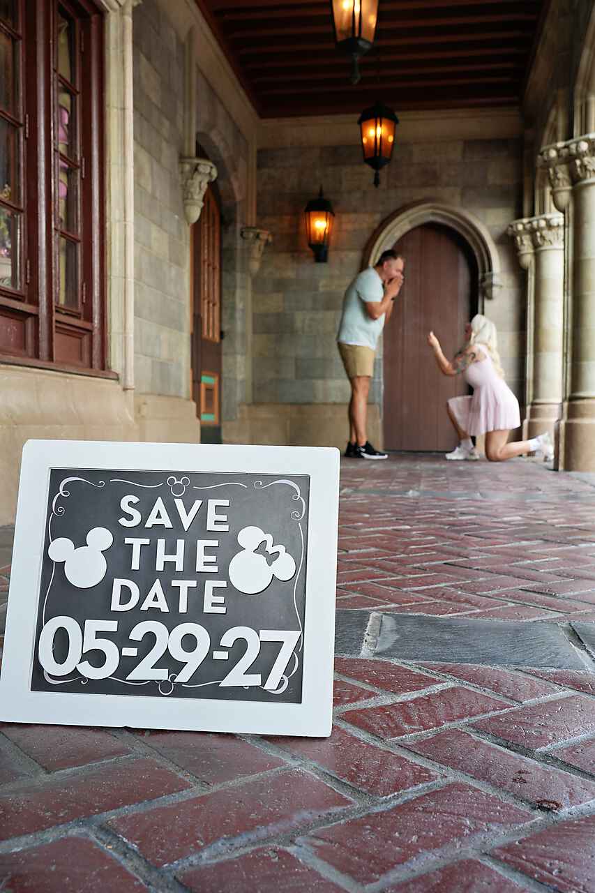 Save the Date chalkboard sign with couple kissing at Cinderella Castle