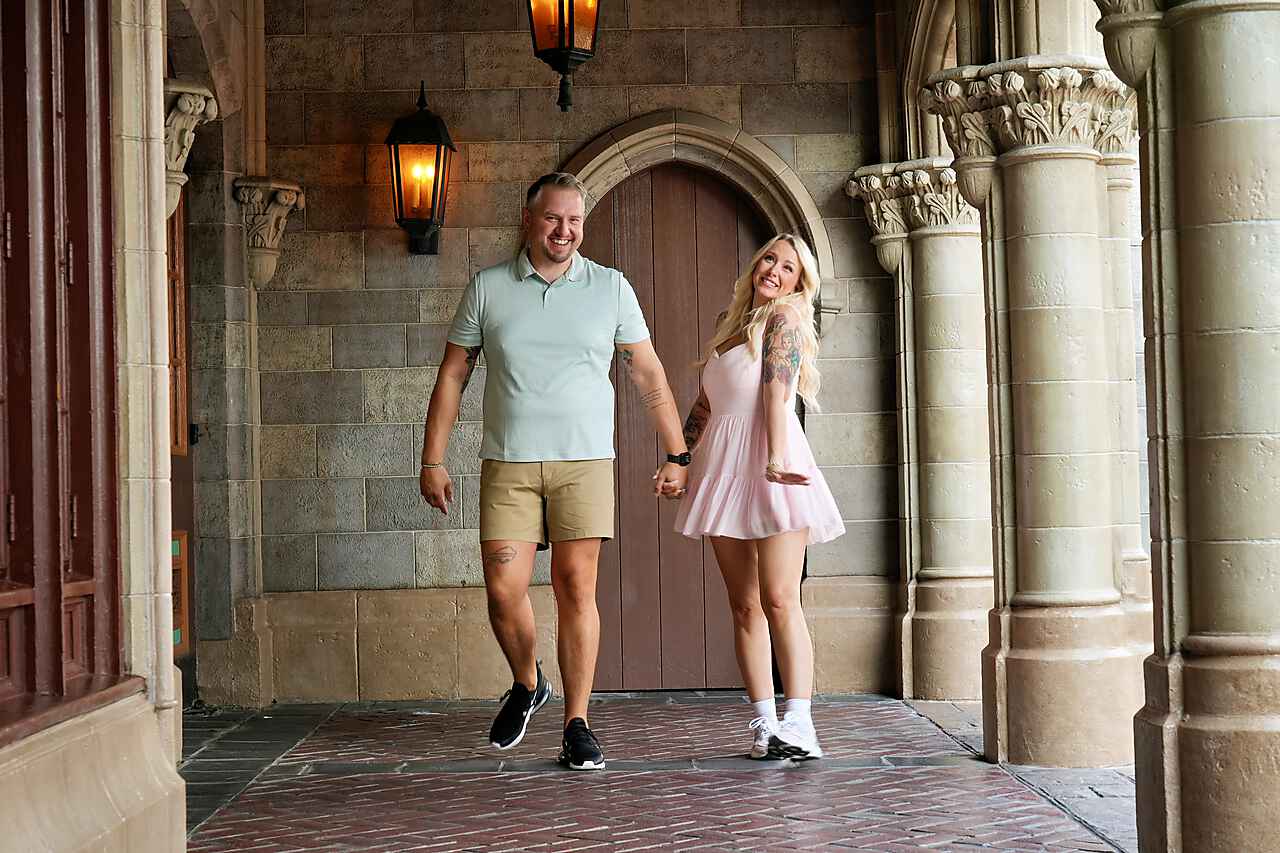 Krystal and Joseph holding hands beneath the castle archway