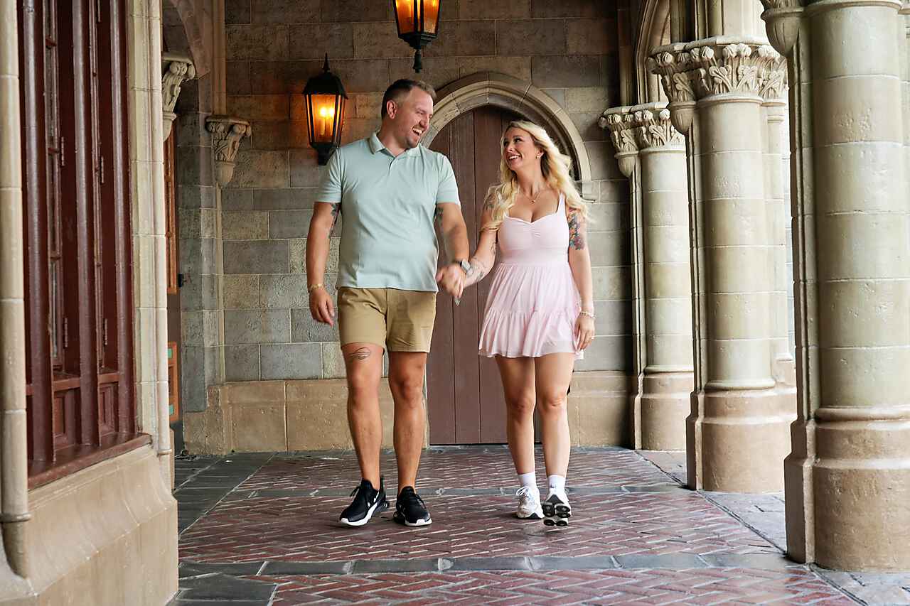 Krystal and Joseph walking hand in hand under the castle arch